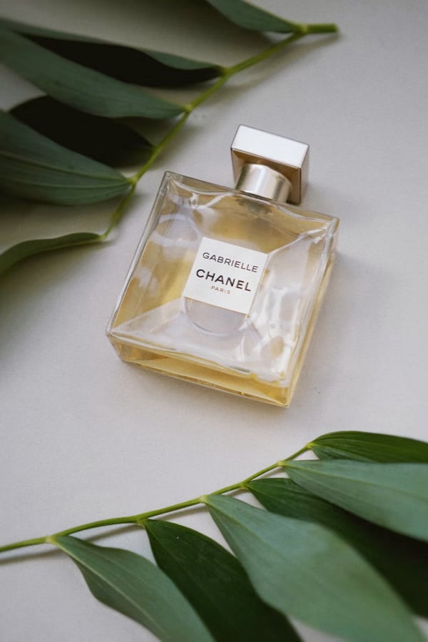 Gabrielle chanel gold parfum near green leafs